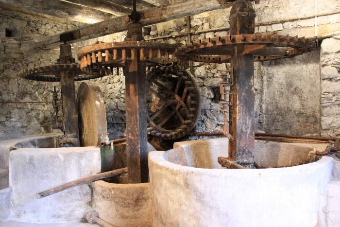 Moulin à huile de Villars-sur-Var. Cliché P. Thomassin, Roudoule.

à gauche :meule et sa piste surmontées du boîtier de débrayage de la meule s'appuyant sur la poutre maîtresse (la jaina)
au centre : rouet (roue dentée verticale) et roue maîtresse d'entrainement et ses alluchons. (roue dentée horizontale)
à droite : débrouilloir